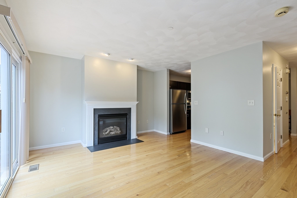 555 Main Street, Unit 10 Woburn, MA 01801 - Photo 15 of 39 a view of an empty room with fire place and a window