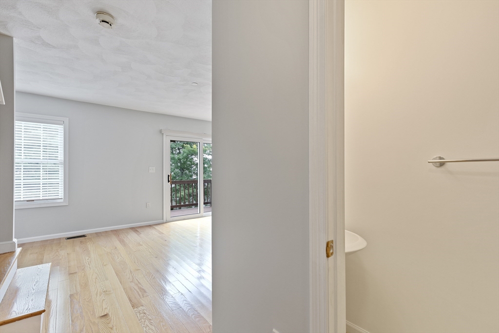 555 Main Street, Unit 10 Woburn, MA 01801 - Photo 18 of 39 a view of an empty room with wooden floor and a window
