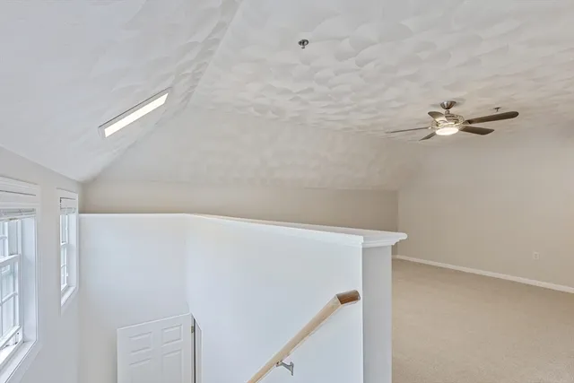 a view of a livingroom with wooden floor and a ceiling fan