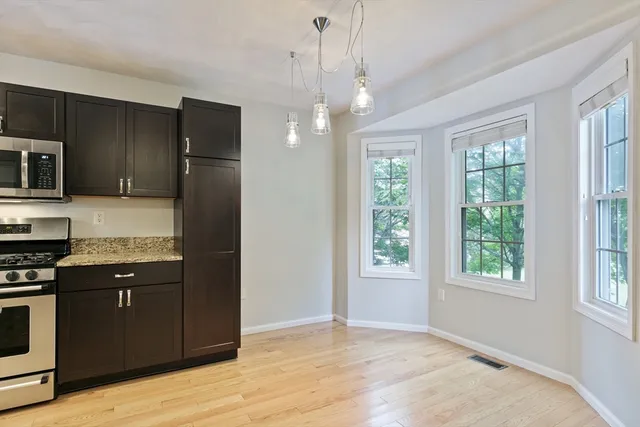 a kitchen with granite countertop wooden cabinets stainless steel appliances and a counter space