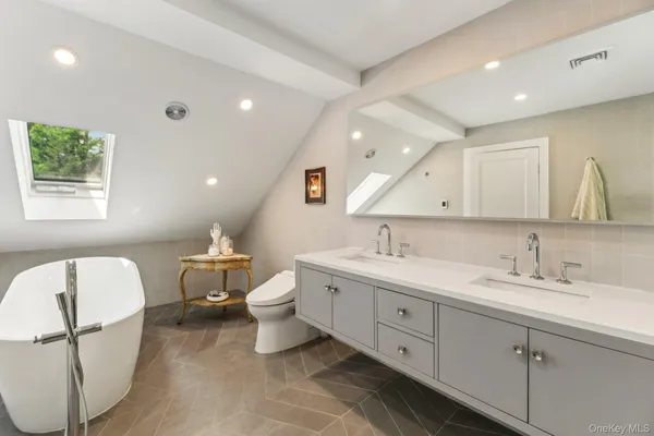 a spacious bathroom with a double vanity sink mirror and toilet