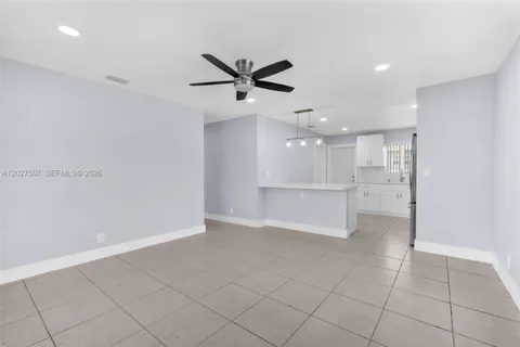 a view of an empty room and kitchen view