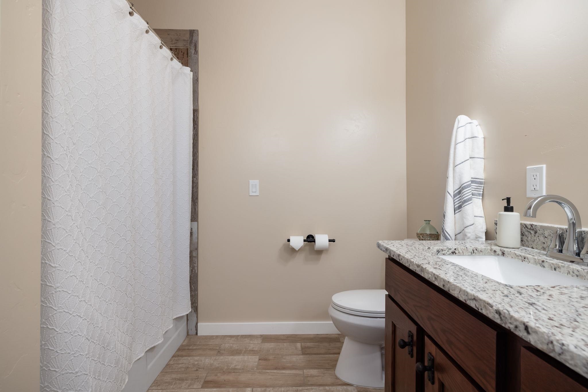 2877 B Road Grand Junction, CO 81503 - Photo 9 of 36 a bathroom with a granite countertop sink toilet and mirror