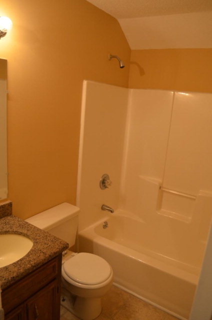 1689 Johnson Road Macon, GA 31220 - Photo 17 of 17 a bathroom with a granite countertop toilet a sink and a shower