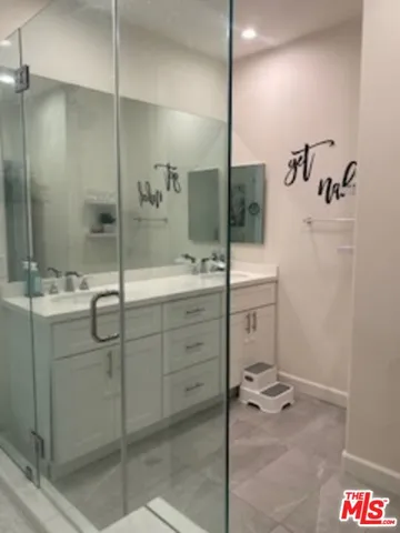 a bathroom with a shower sink and mirror