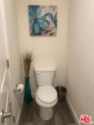 a white toilet sitting next to a white wall