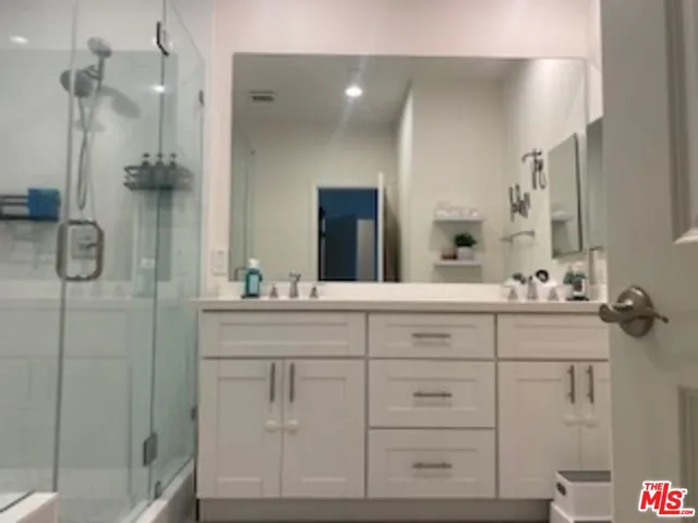 a bathroom with a double vanity sink mirror and shower