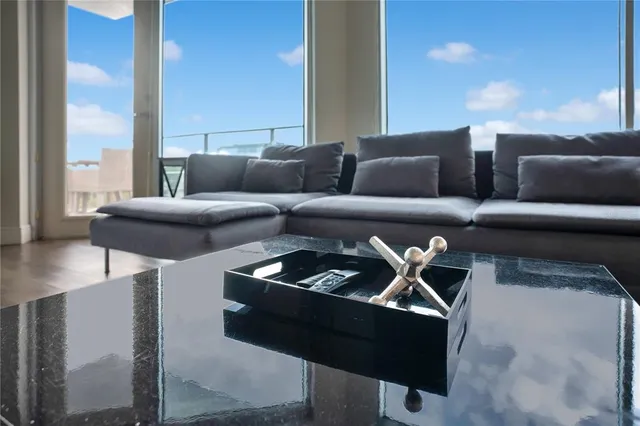 a living room with furniture kitchen view and a wooden floor