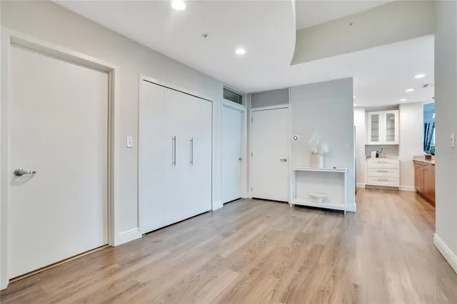 a kitchen with stainless steel appliances kitchen island granite countertop a refrigerator a sink a stove and a wooden floors