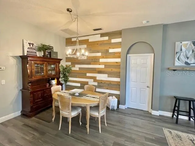 a dining room with furniture and wooden floor