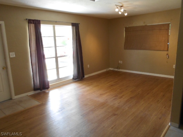 1419 Mandel Road Fort Myers, FL 33919 - Photo 3 of 18 an empty room with wooden floor and windows