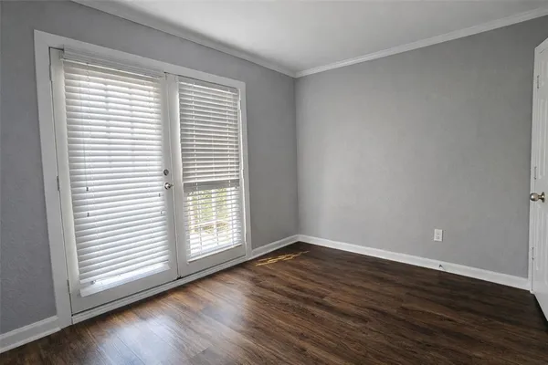 an empty room with wooden floor and a window