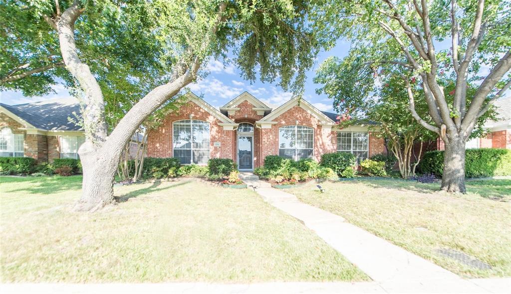 334 Touchdown Drive Irving, TX 75063 - Photo 3 of 32 Brick facade residence featuring a covered entry, arched transom window, bay windows, mature trees, and a concrete walkway