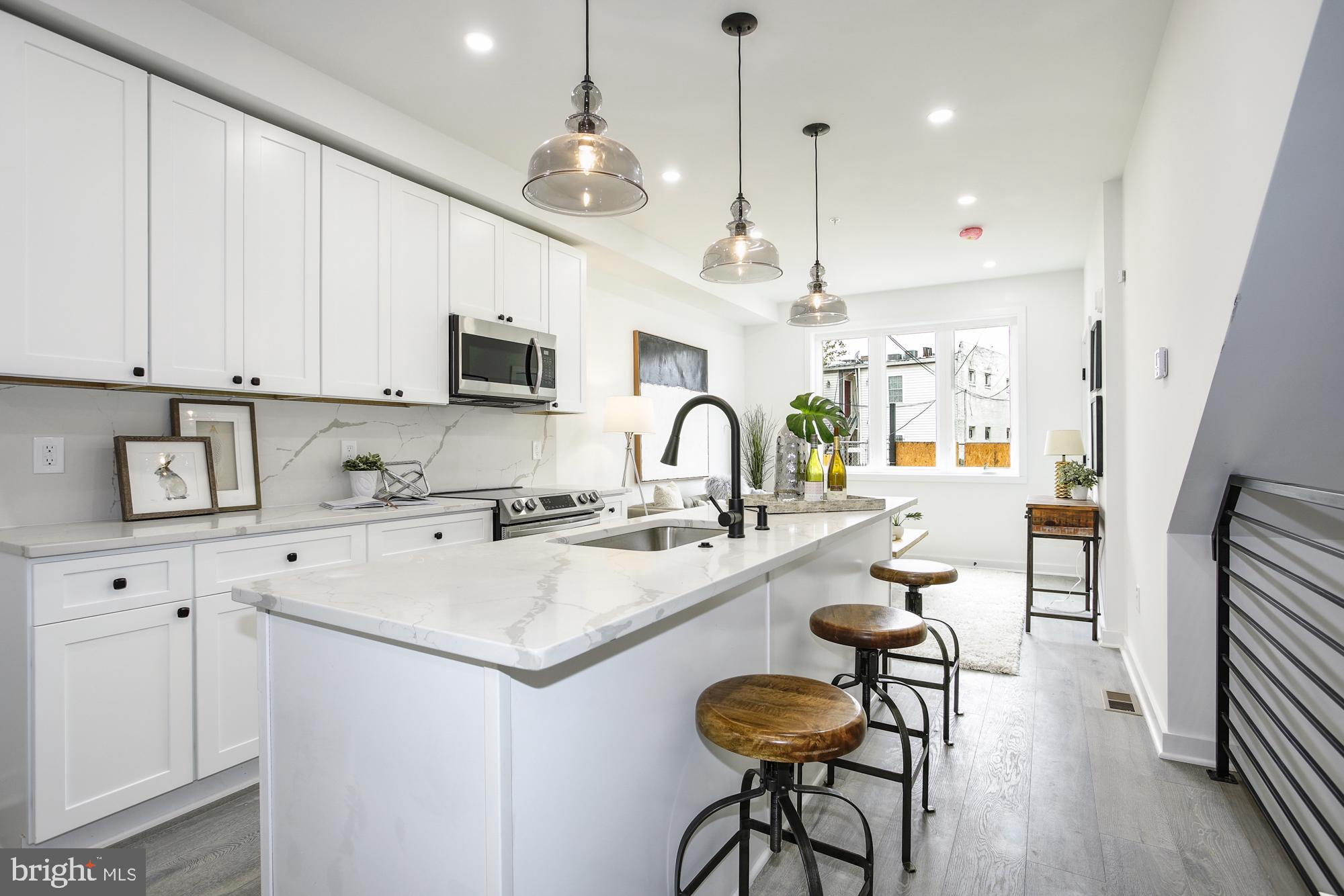 1730 Montello Avenue Northeast, Unit 2 Washington, DC 20002 - Photo 2 of 14 a kitchen with sink stove and white cabinets with wooden floor