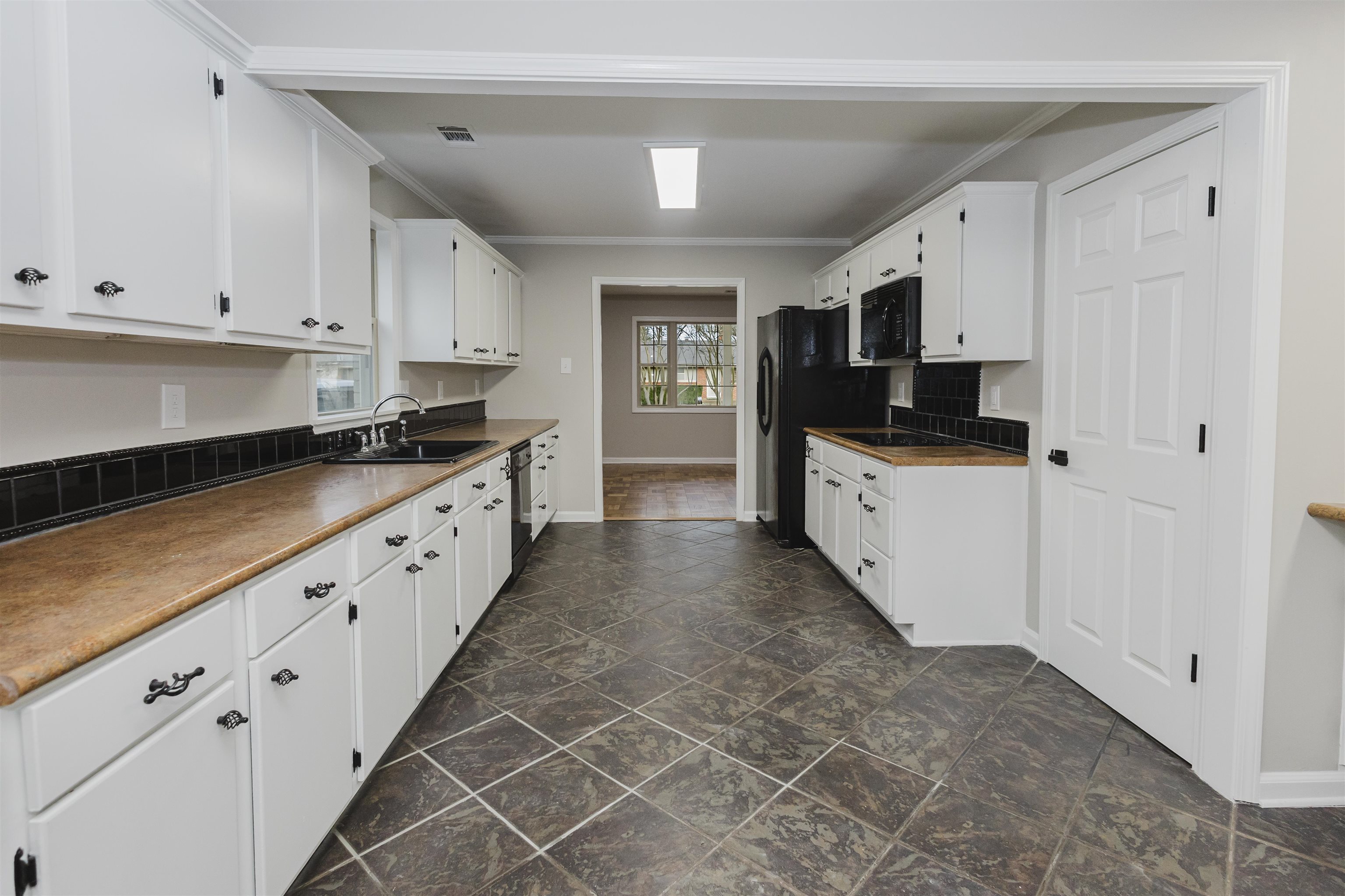 421 McDermitt Road Memphis, TN 38120 - Photo 11 of 23 a large white kitchen with granite countertop a sink and dishwasher a stove top oven with white cabinets