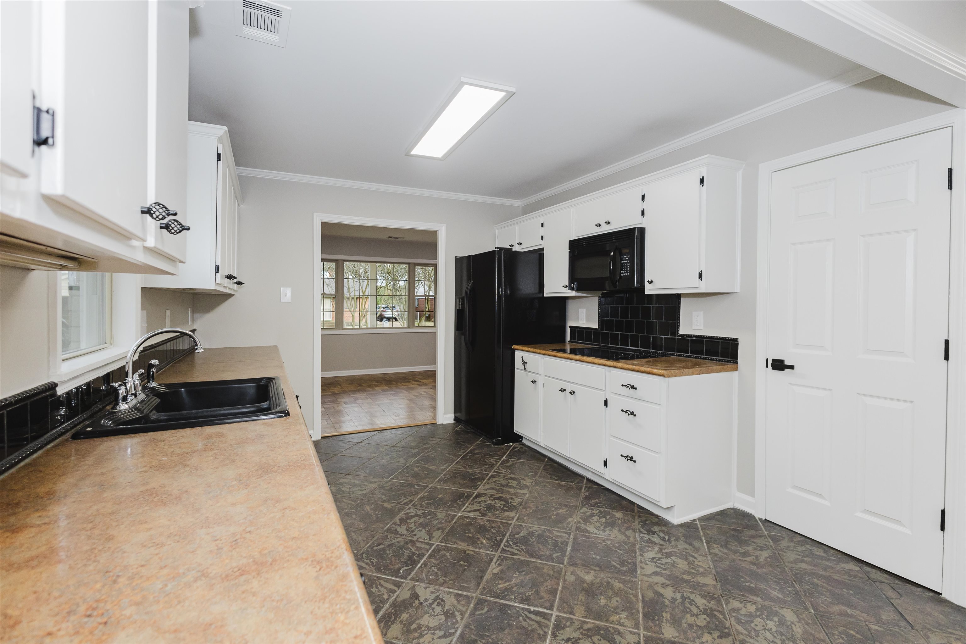421 McDermitt Road Memphis, TN 38120 - Photo 7 of 23 a kitchen with granite countertop white cabinets and black stainless steel appliances