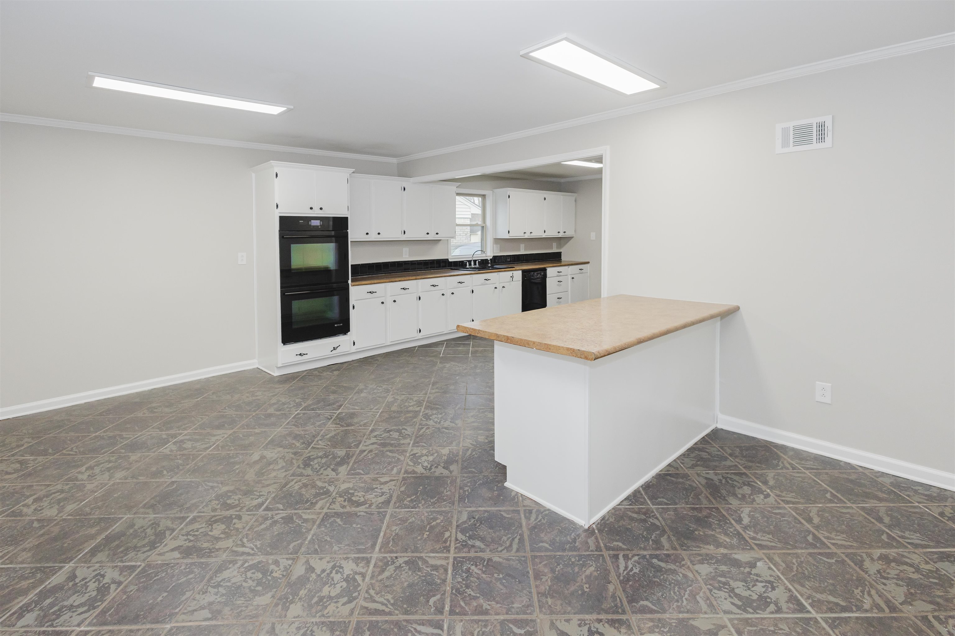 421 McDermitt Road Memphis, TN 38120 - Photo 8 of 23 a view of kitchen with refrigerator stove microwave and white cabinets