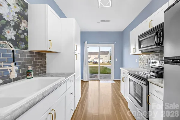 a kitchen with stainless steel appliances a stove sink microwave and cabinets
