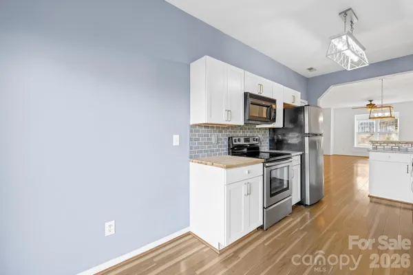 a kitchen with granite countertop white cabinets and stainless steel appliances