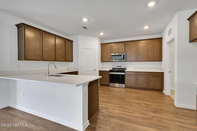 a kitchen with granite countertop a stove and a wooden floor