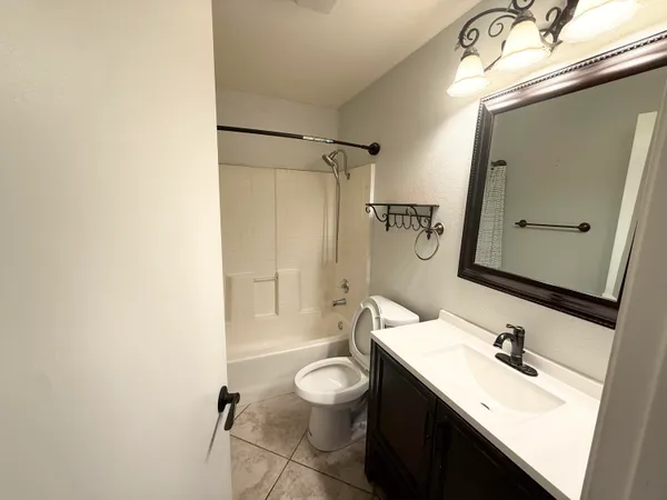 a bathroom with a double vanity sink toilet mirror and shower