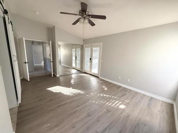a view of a livingroom with wooden floor and a ceiling fan