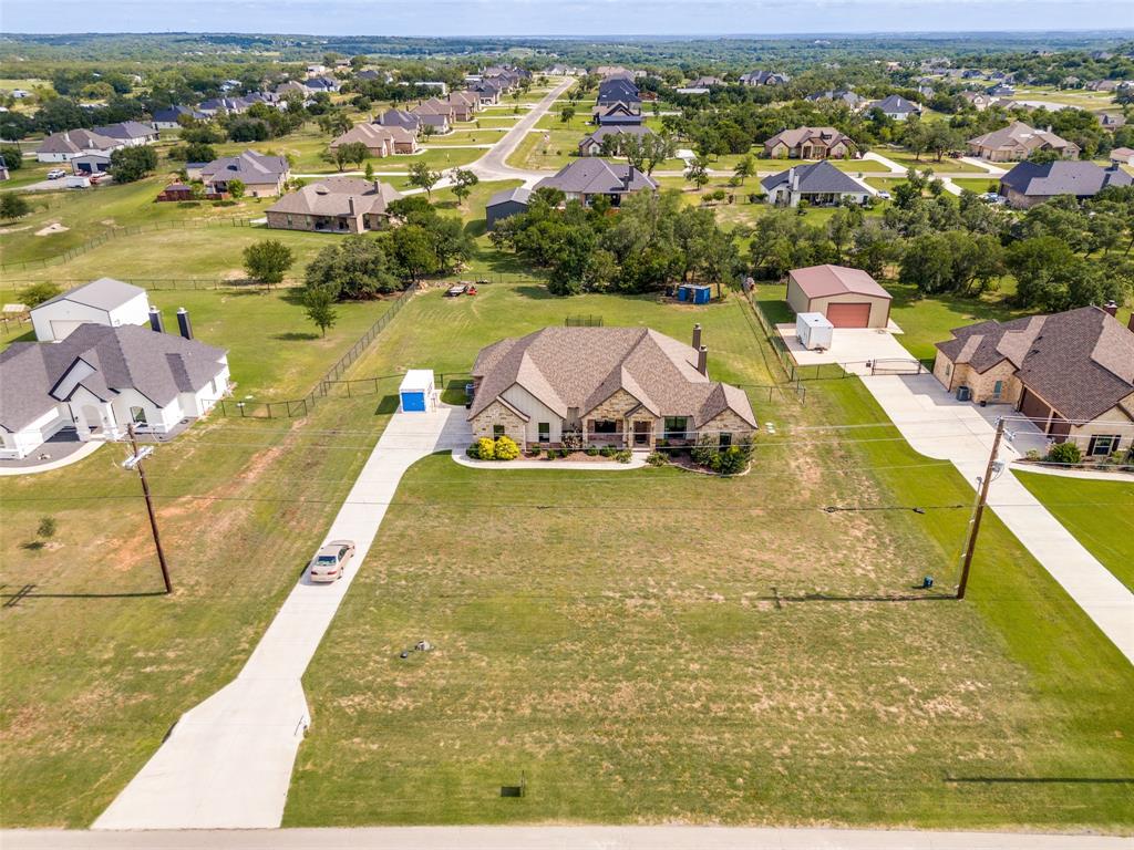 6913 Veal Station Road Weatherford, TX 76085 - Photo 27 of 31 Stone and brick facade residence with an attached garage, featuring a long concrete driveway