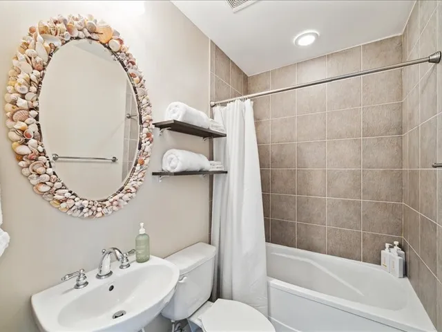 a bathroom with a sink mirror toilet and bathtub