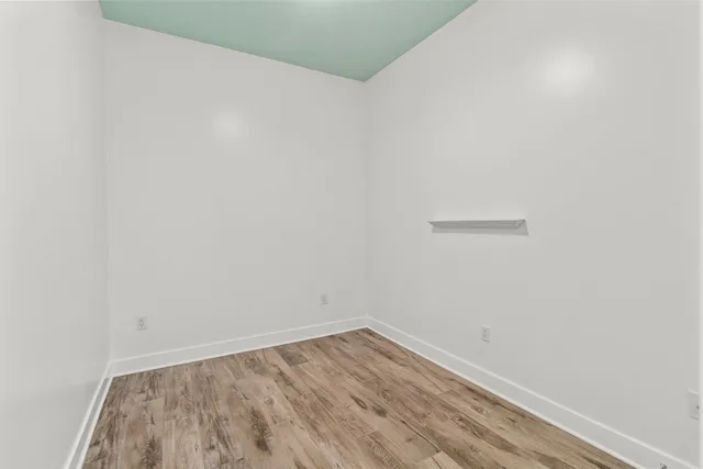 a view of a small space with wooden floor and a window