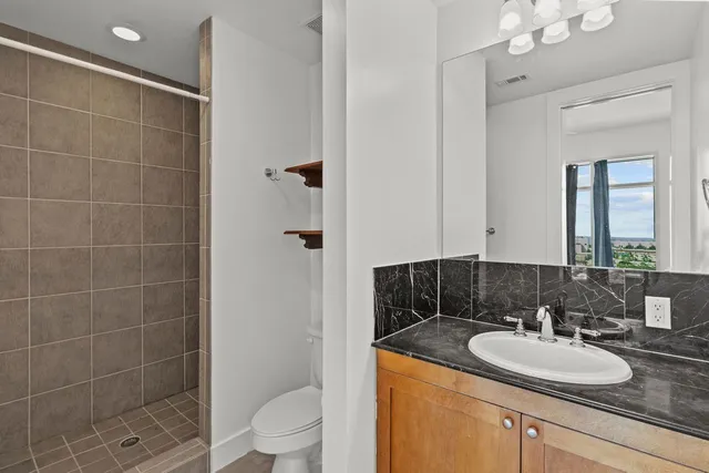 a bathroom with a sink a toilet and shower