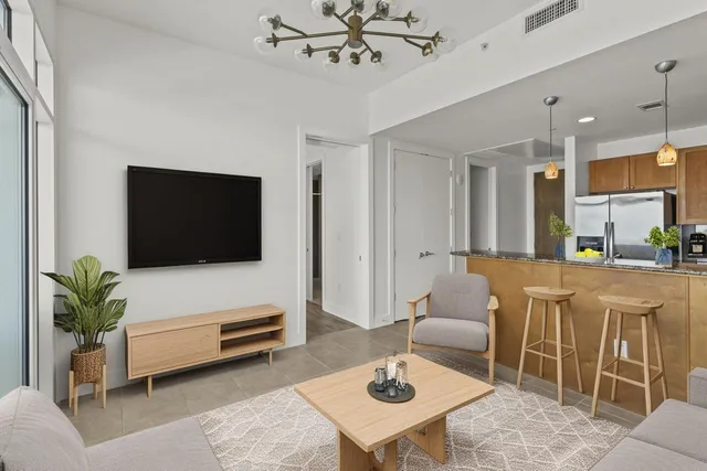 a living room with furniture a flat screen tv and a table