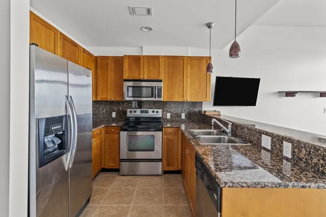 a kitchen with stainless steel appliances granite countertop a sink stove and refrigerator