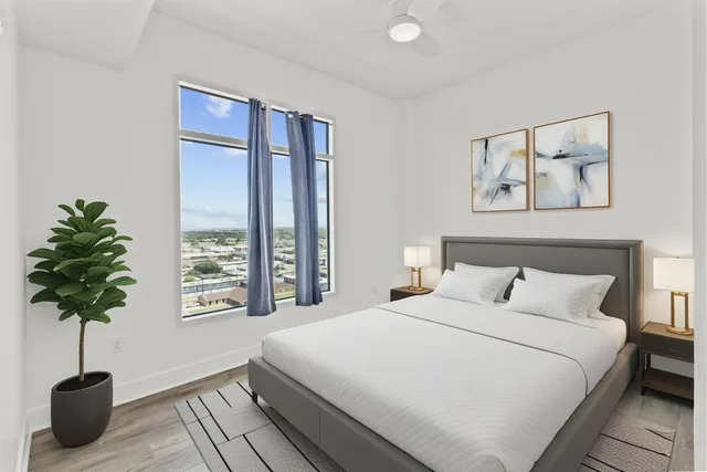 a bedroom with a large bed and a potted plant
