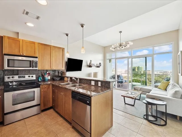 a kitchen with kitchen island granite countertop a sink counter top space appliances and cabinets