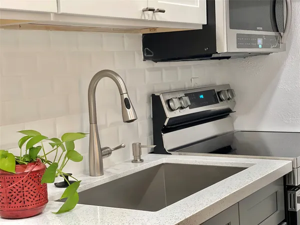 a view of kitchen sink microwave and stove
