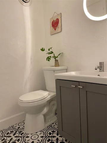 a bathroom with a sink toilet and a mirror