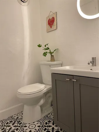 a bathroom with a sink toilet and a mirror