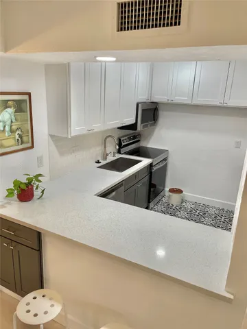 a kitchen with a sink a stove and cabinets