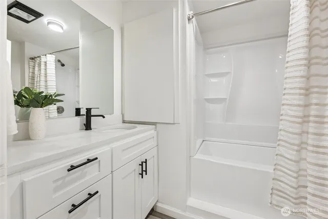 a bathroom with a tub sink and mirror