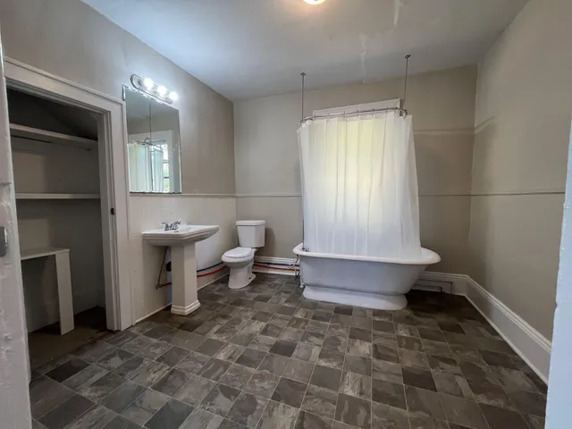 a bathroom with a toilet a sink and bathtub