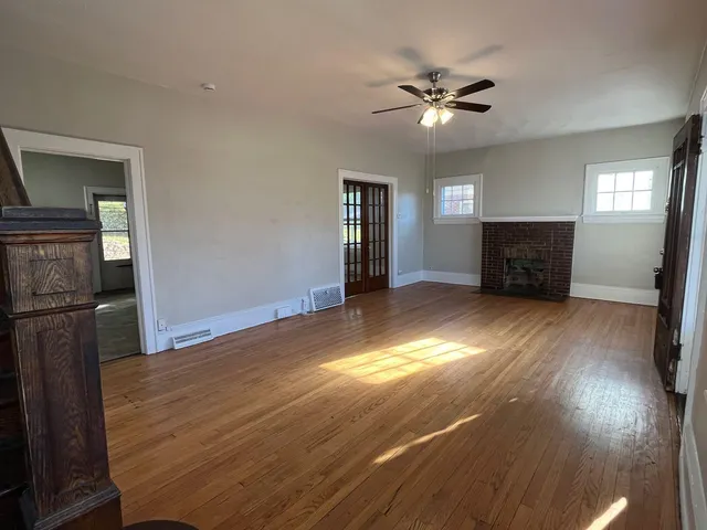 a view of empty room with wooden floor
