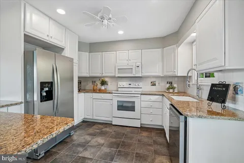 a kitchen with stainless steel appliances granite countertop a refrigerator and a stove