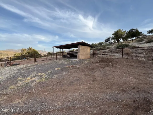 a view of a dry yard with wooden fence