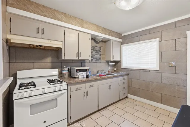 a kitchen with cabinets appliances a sink and a window