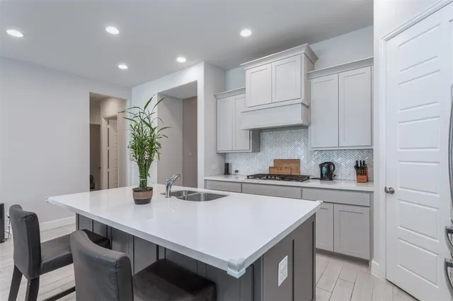 a kitchen with a sink a stove and chairs