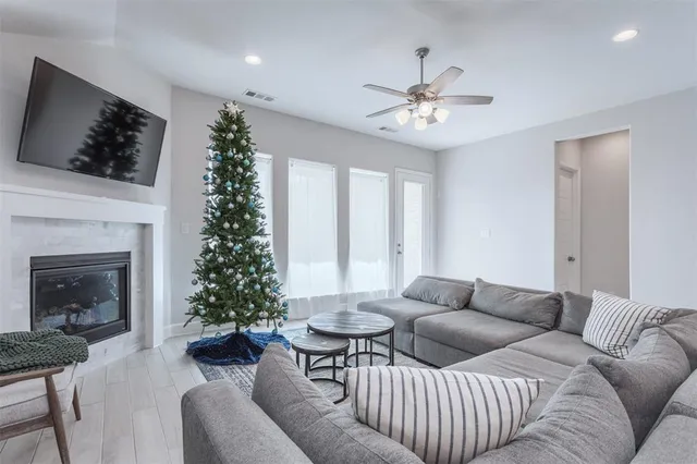 a living room with furniture a flat screen tv and a fireplace