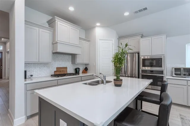a kitchen with stainless steel appliances a sink a stove and refrigerator