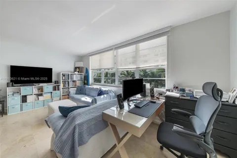 a living room with furniture a flat screen tv and a floor to ceiling window