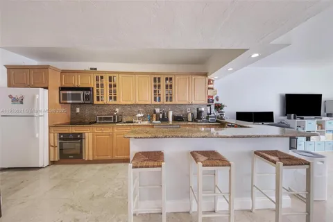 a kitchen with cabinets and chairs