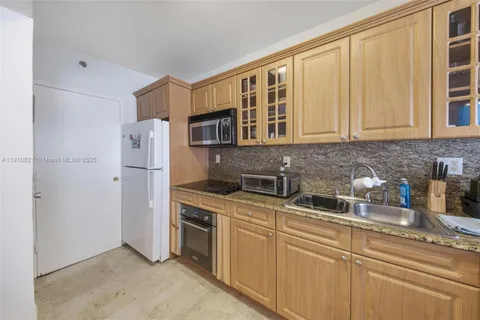 a kitchen with stainless steel appliances granite countertop a refrigerator sink and cabinets